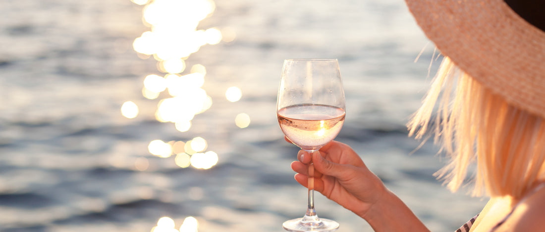 wine, wine glass, being held out by women, with water in background